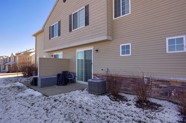 snow covered property with central AC unit