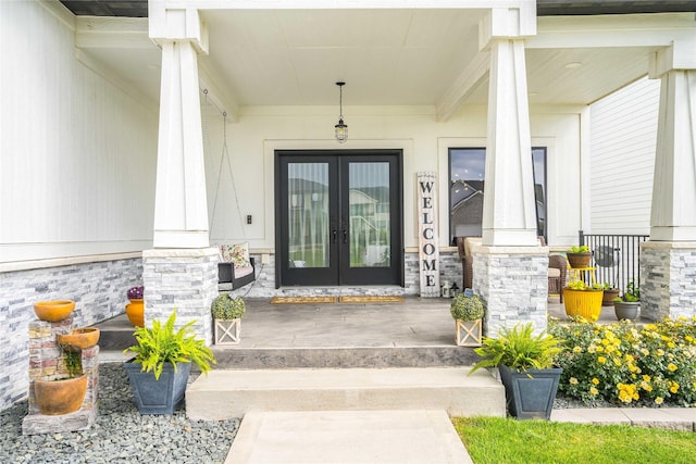 doorway to property featuring a porch and french doors