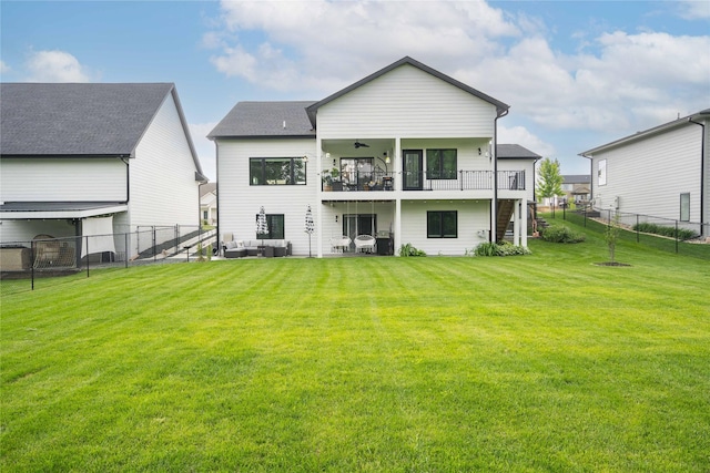 back of house with a lawn, ceiling fan, and a balcony