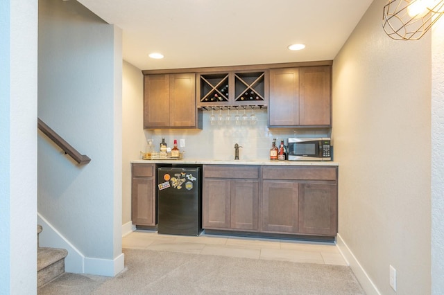 bar featuring decorative backsplash, stairway, stainless steel microwave, indoor wet bar, and a sink