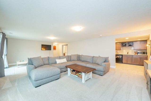 living room with light carpet, indoor wet bar, and baseboards