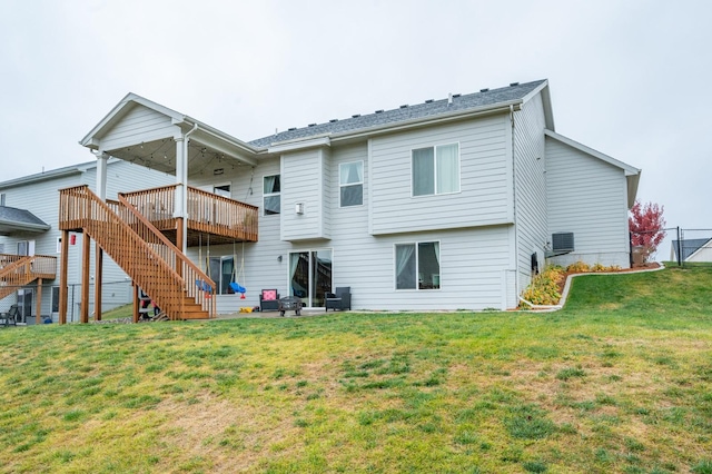 rear view of house featuring a yard, stairway, fence, and a wooden deck