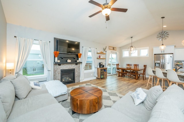 931 Breakwater Pl, Polk City, IA 50226 - living room featuring plenty of natural light, light wood finished floors, a brick fireplace, a ceiling fan, and lofted ceiling