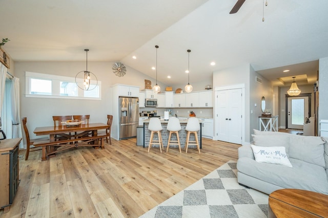 living area featuring lofted ceiling, ceiling fan, light wood-type flooring, and recessed lighting