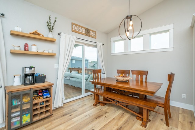 dining room with vaulted ceiling, light wood-style flooring, and baseboards