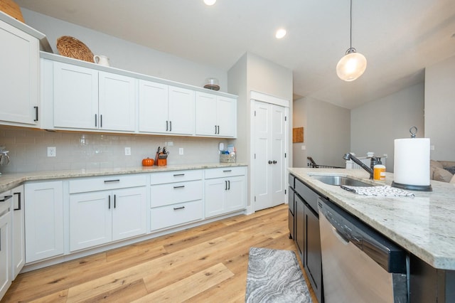 kitchen featuring a sink, white cabinets, stainless steel dishwasher, and hanging light fixtures