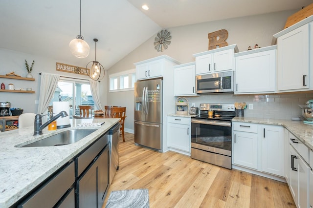 kitchen with appliances with stainless steel finishes, a sink, and white cabinets