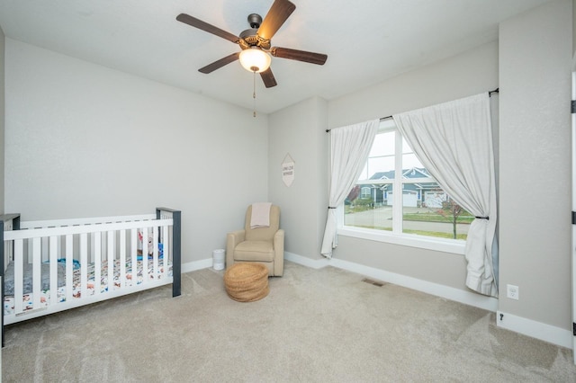 bedroom featuring a nursery area, visible vents, baseboards, and carpet flooring