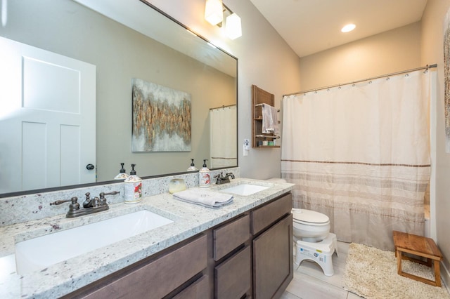 bathroom with tile patterned flooring, a sink, toilet, and double vanity