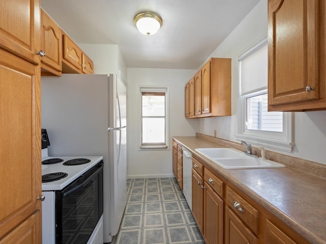 kitchen featuring a wealth of natural light, sink, and white appliances