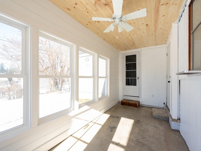 unfurnished sunroom with ceiling fan, a healthy amount of sunlight, wood ceiling, and vaulted ceiling