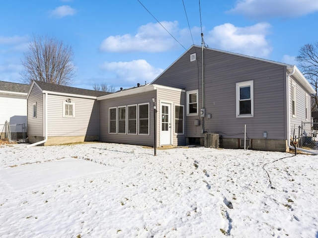 snow covered rear of property with central AC unit