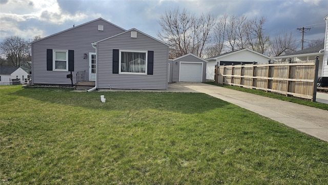view of front of house with an outbuilding, a detached garage, fence, a front lawn, and concrete driveway