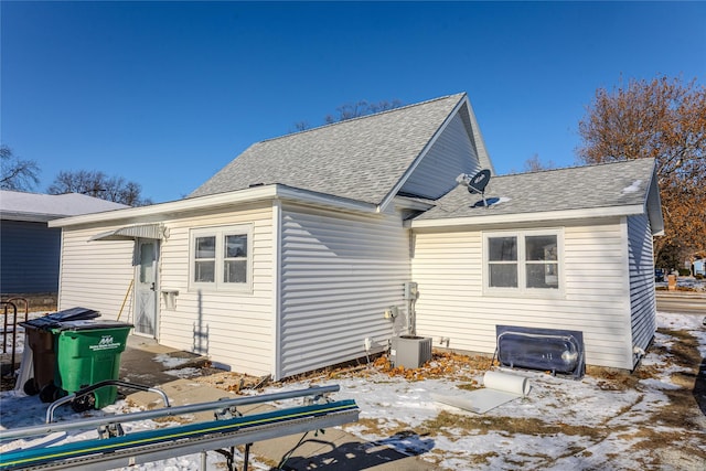 snow covered property featuring central AC