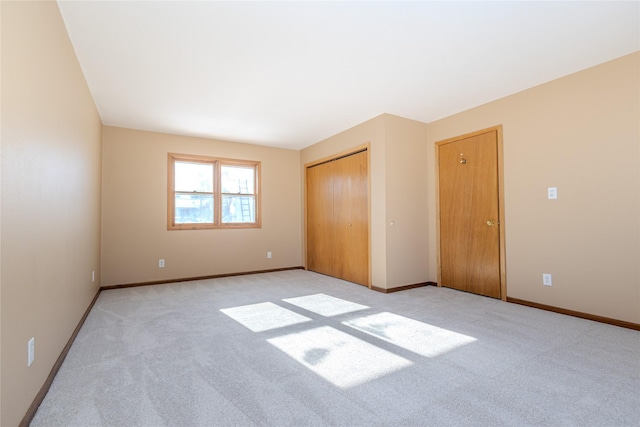 unfurnished bedroom featuring light carpet and a closet