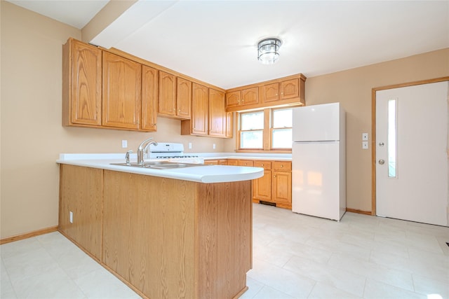 kitchen with kitchen peninsula, stove, white refrigerator, and sink