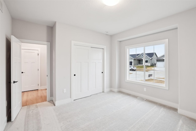 bedroom featuring light carpet and a closet