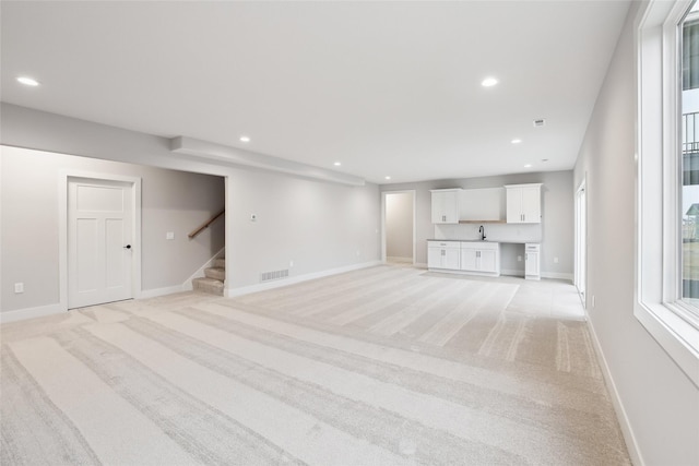 unfurnished living room featuring light carpet