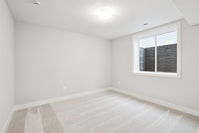 carpeted spare room with a textured ceiling