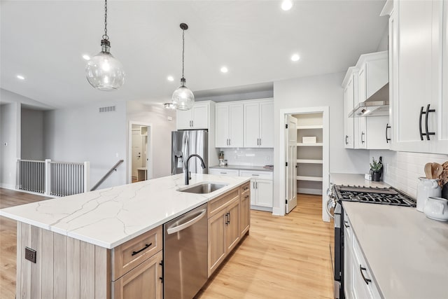 kitchen with white cabinetry, a center island with sink, stainless steel appliances, and sink