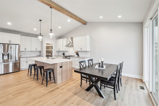 kitchen with decorative backsplash, appliances with stainless steel finishes, sink, decorative light fixtures, and an island with sink