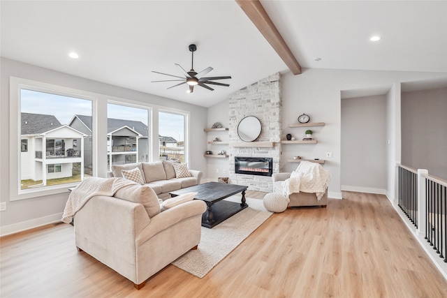 living room with vaulted ceiling with beams, light hardwood / wood-style flooring, and a healthy amount of sunlight