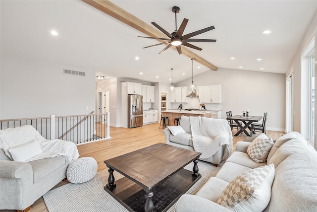 living room with lofted ceiling with beams, ceiling fan, and light hardwood / wood-style flooring