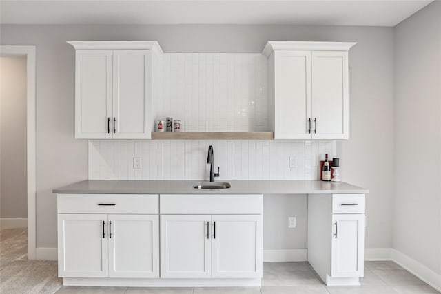 kitchen with decorative backsplash, white cabinetry, and sink