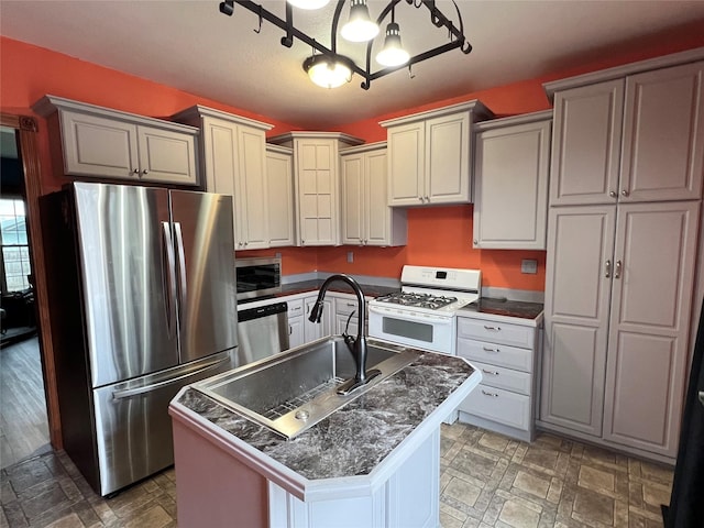 kitchen with sink, a kitchen island with sink, and appliances with stainless steel finishes