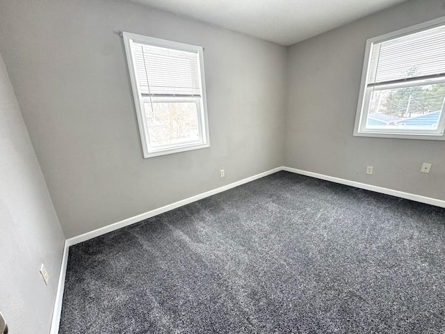 spare room featuring carpet floors and baseboards