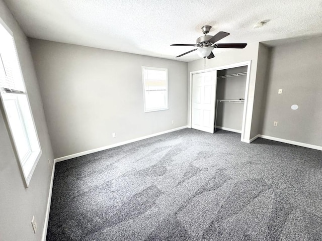 unfurnished bedroom with a closet, carpet floors, baseboards, a textured ceiling, and a ceiling fan