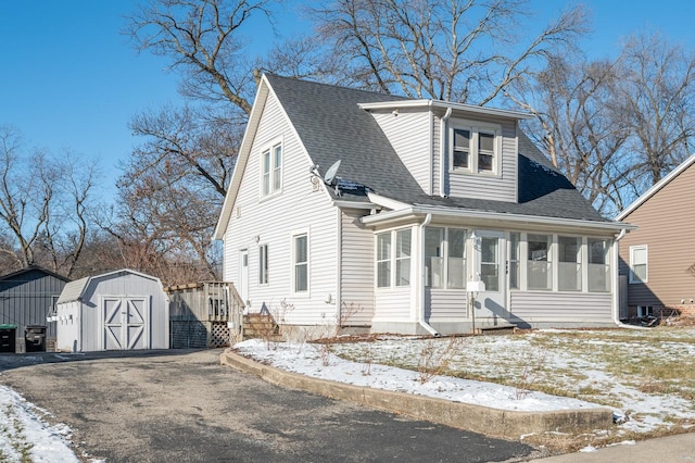 view of front of house featuring a storage unit and a sunroom