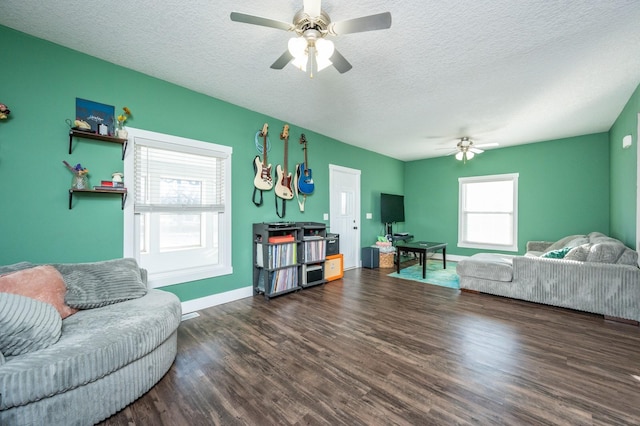 living room featuring dark wood-type flooring, a healthy amount of sunlight, and a textured ceiling