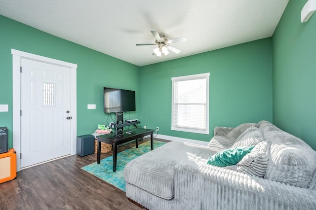 living room featuring ceiling fan and dark wood-type flooring