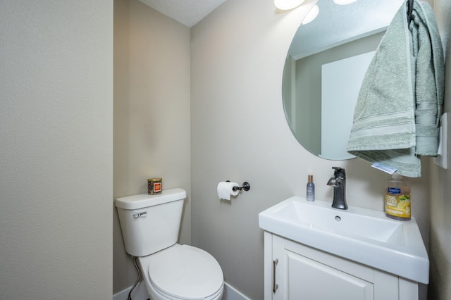 bathroom featuring vanity, a textured ceiling, and toilet