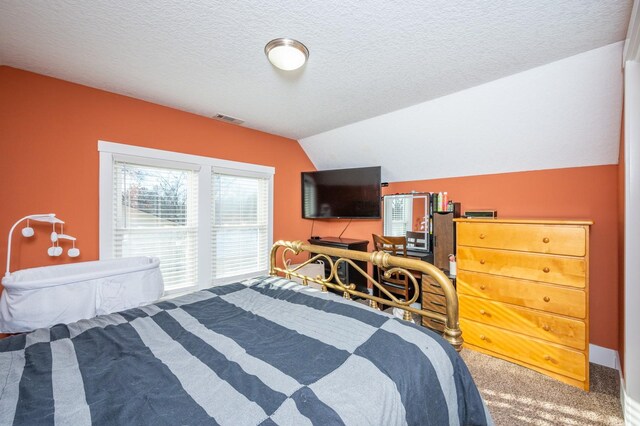 bedroom with carpet flooring, a textured ceiling, and vaulted ceiling