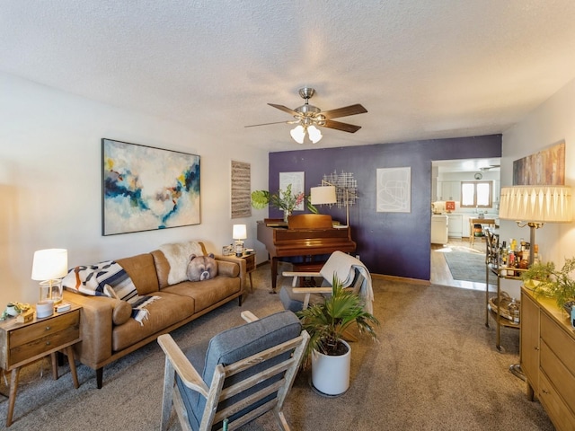 living room featuring a textured ceiling, carpet floors, and ceiling fan