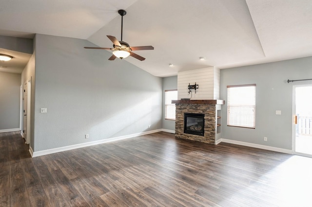 unfurnished living room featuring vaulted ceiling, a stone fireplace, ceiling fan, and dark wood-type flooring