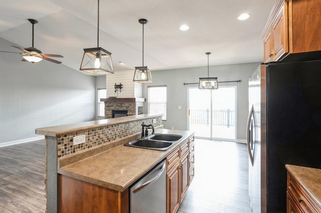 kitchen with pendant lighting, dark wood-type flooring, sink, ceiling fan, and stainless steel appliances