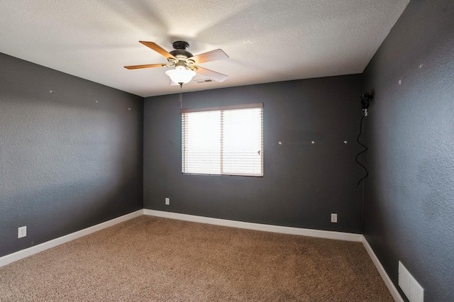 carpeted empty room with ceiling fan and a textured ceiling