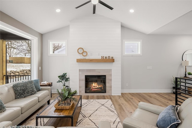 living room featuring a fireplace, lofted ceiling with beams, light hardwood / wood-style flooring, and ceiling fan