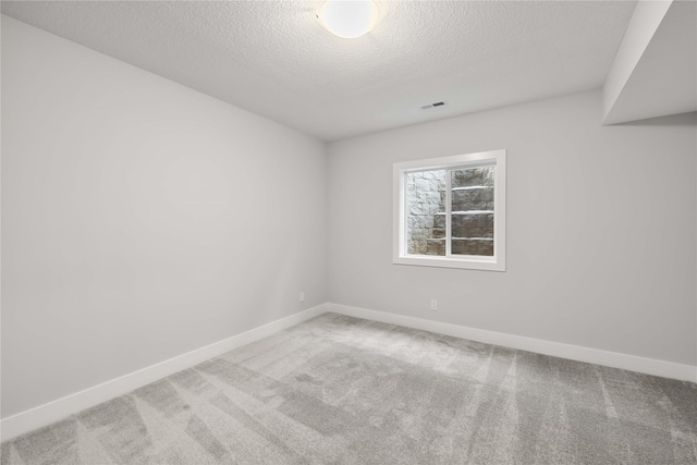 carpeted empty room with a textured ceiling