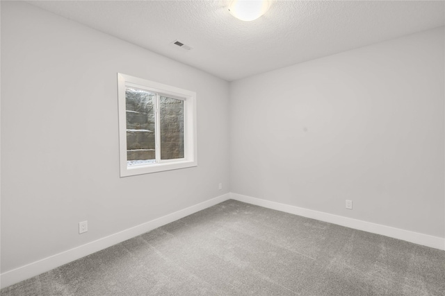 carpeted spare room with a textured ceiling