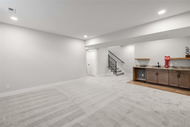 basement featuring light carpet and wet bar