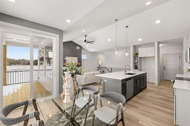 kitchen with pendant lighting, white cabinets, ceiling fan, an island with sink, and a wealth of natural light