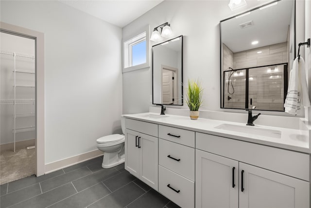 bathroom with tile patterned flooring, vanity, toilet, and a shower with shower door