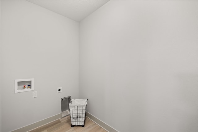 washroom with hookup for an electric dryer, light hardwood / wood-style floors, and washer hookup