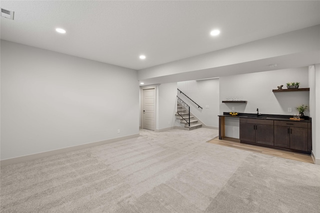 basement featuring light colored carpet and indoor wet bar