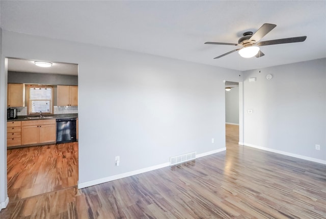 unfurnished room featuring ceiling fan, hardwood / wood-style floors, and sink