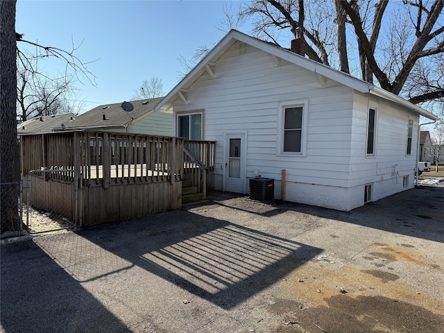 rear view of house featuring cooling unit and a deck